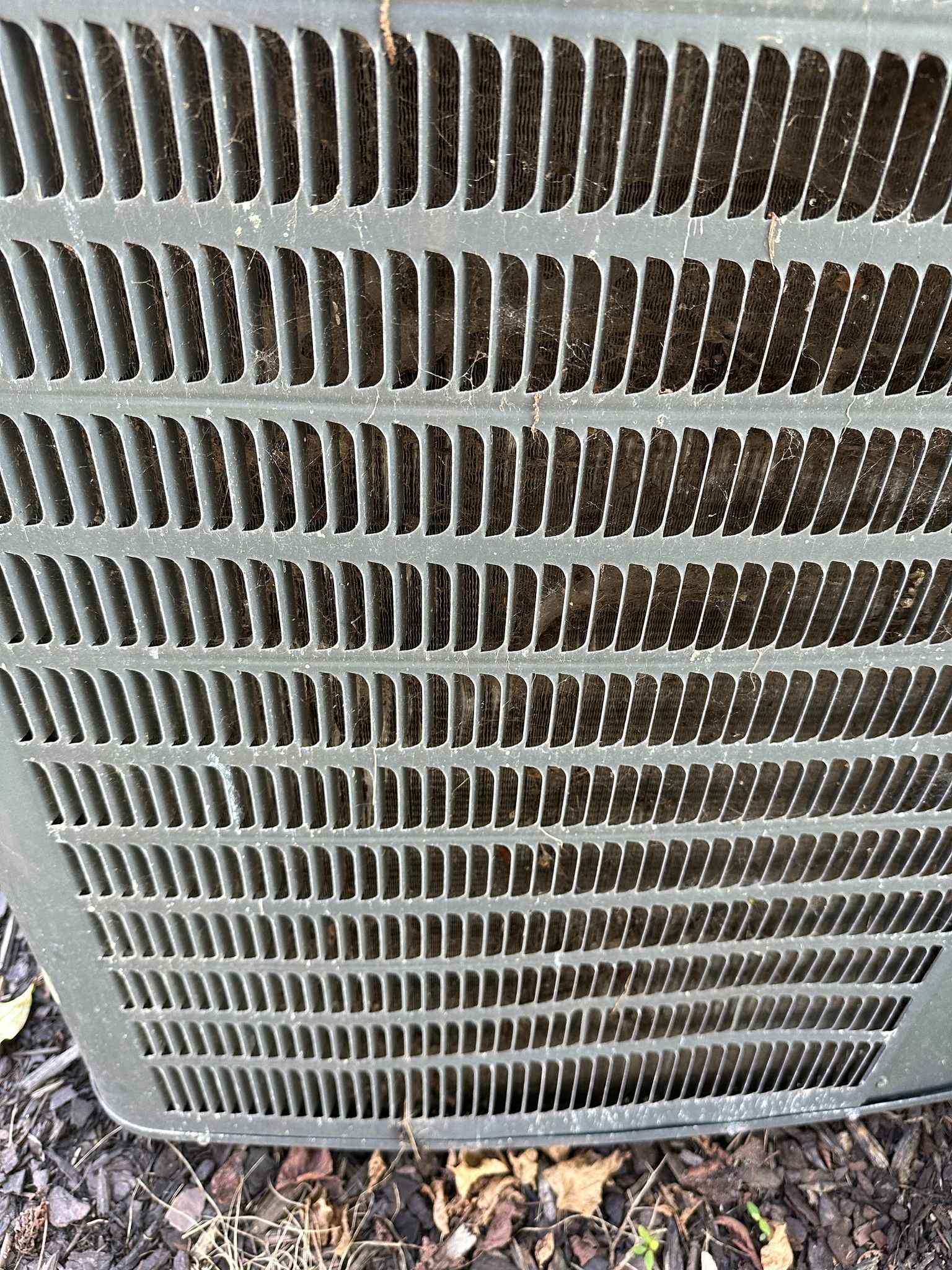 A close up of a air conditioner grille sitting on the ground.