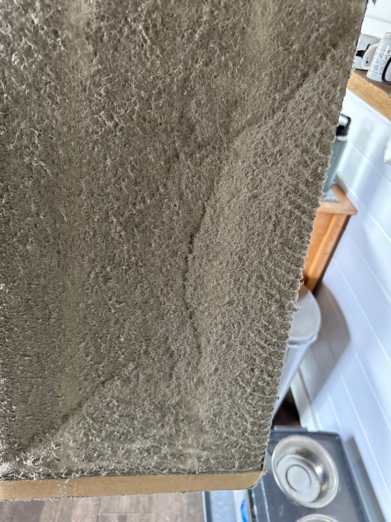 A close up of a piece of carpet in a kitchen.