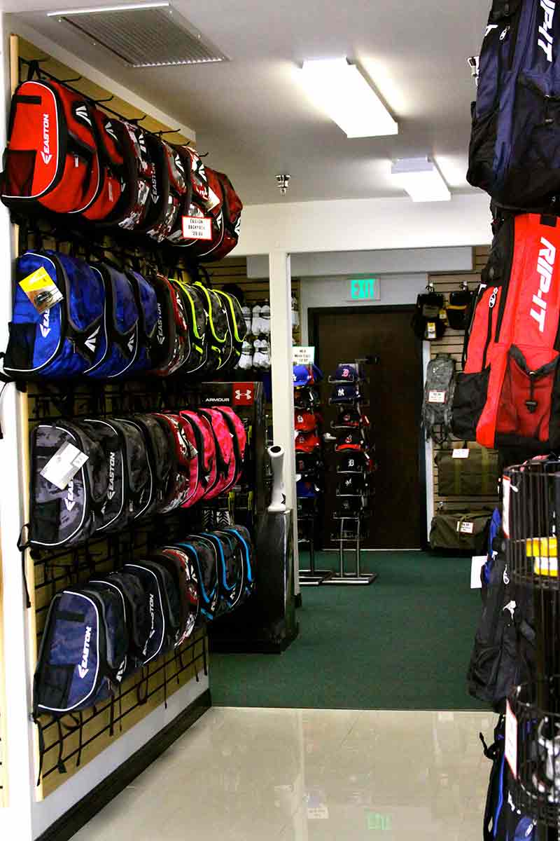 Interior view of Jeffs Sporting Goods baseball section with a large selection of baseball bags and baseball backpacks and softball bags in  their San Gabriel store