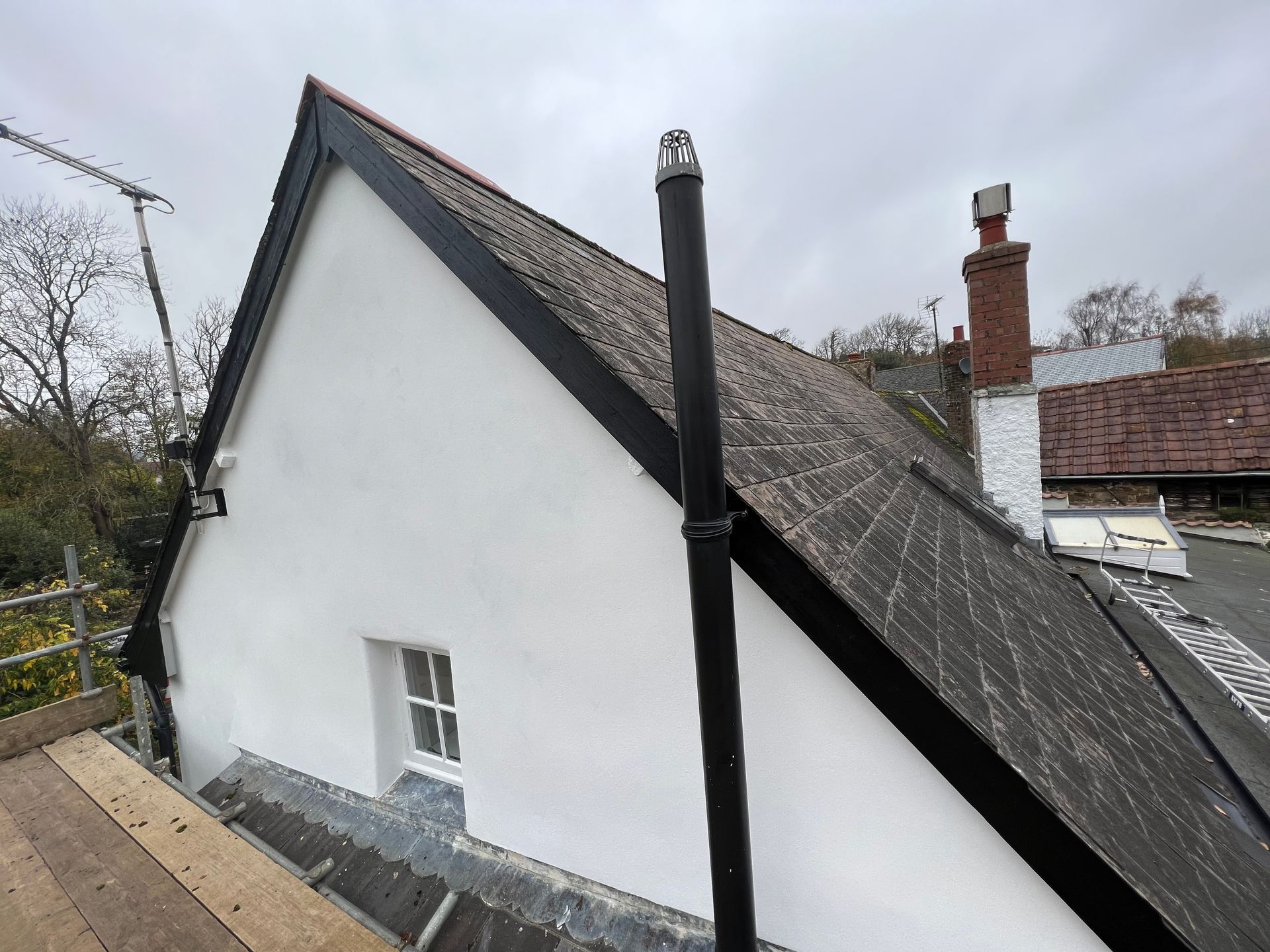 A white house with a black chimney on the roof