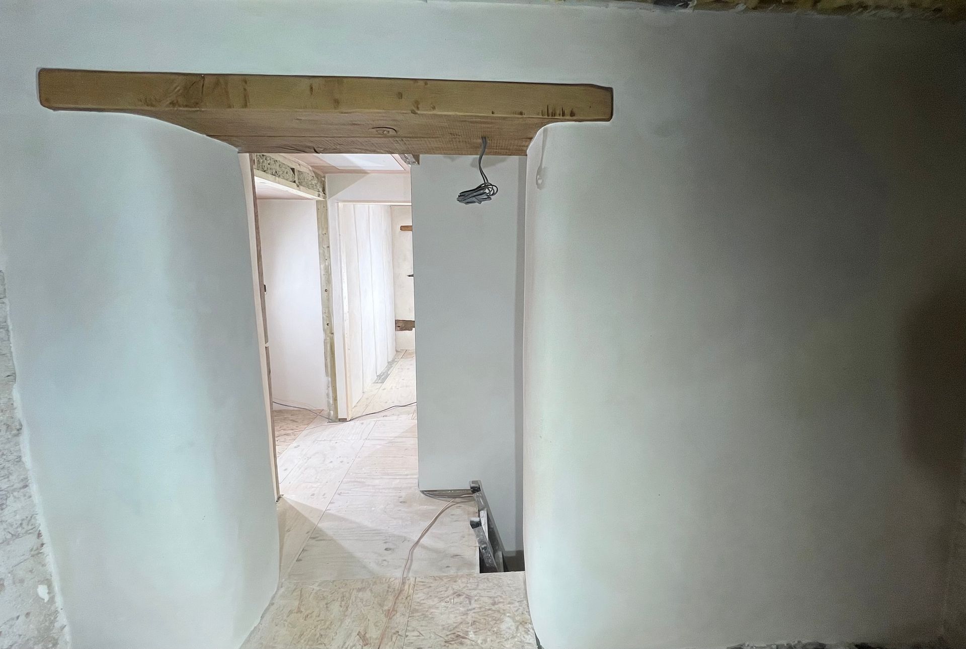 A white wall with a wooden beam above it
