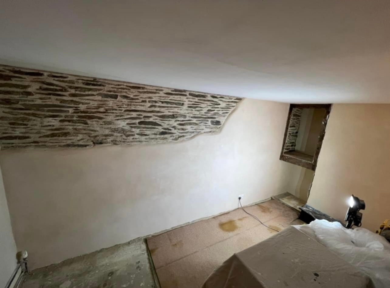 A room with a stone wall and a window.