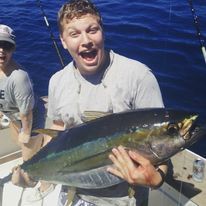 A man is holding a tuna caught on OC's 30 Deep