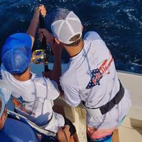 A group of men are fishing on a boat in the ocean.