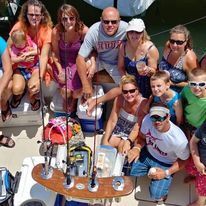 A group of people are posing for a picture on a boat.