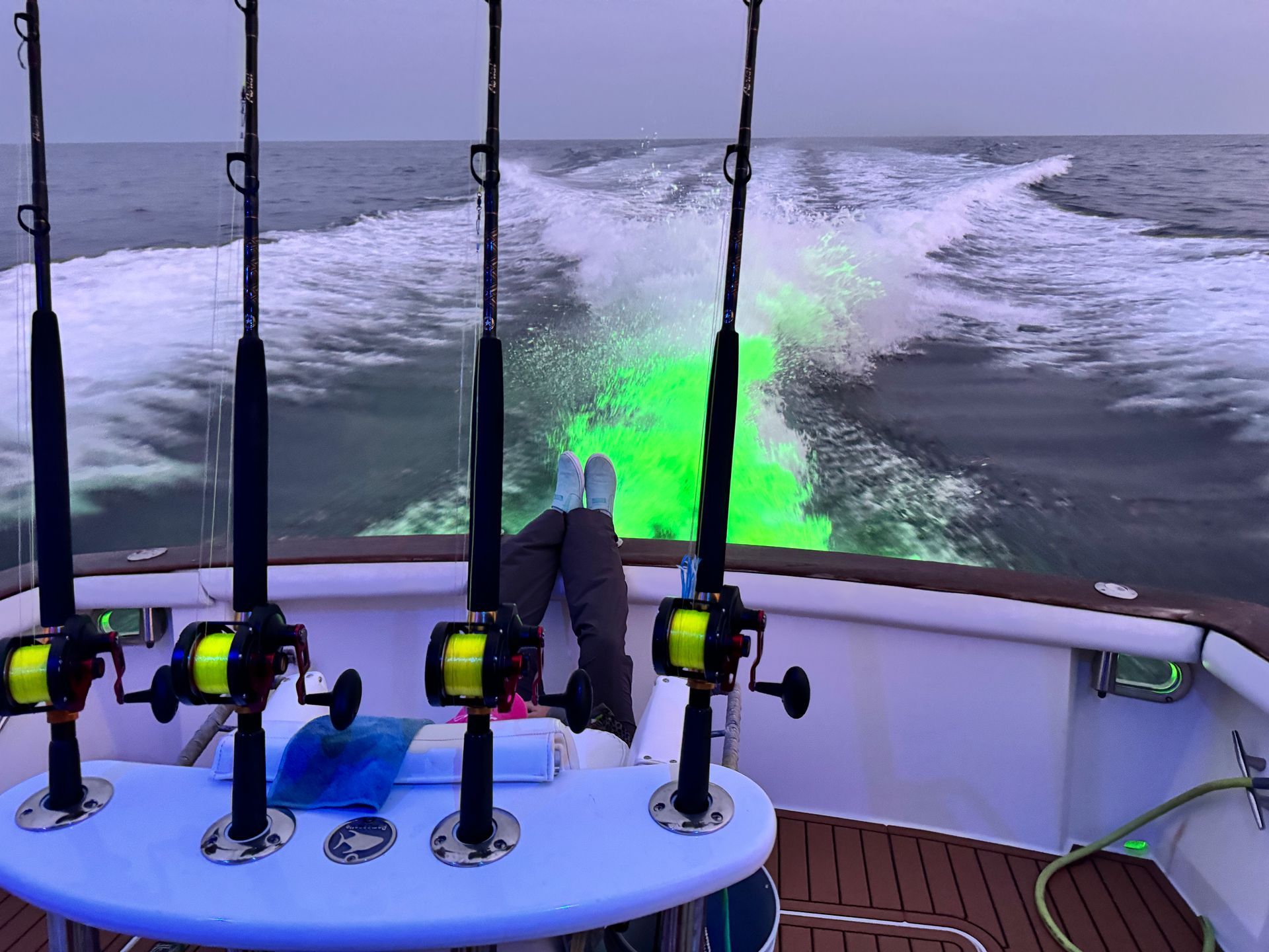 Several fishing rods are on a boat in the ocean