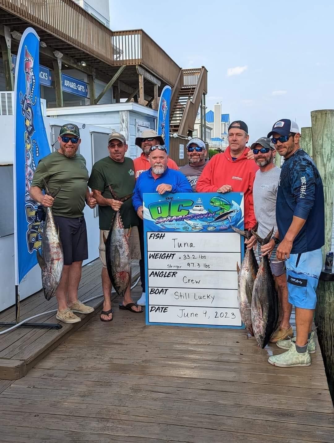 A group of men standing next to each other holding fish