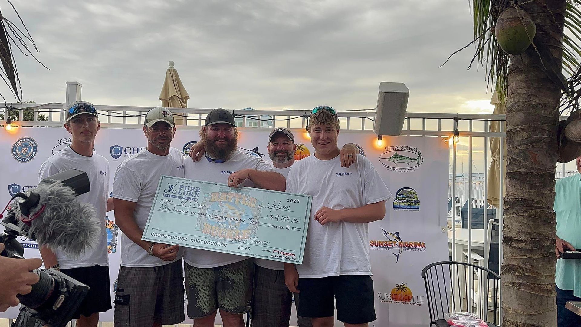 A group of men standing next to each other holding a winning check