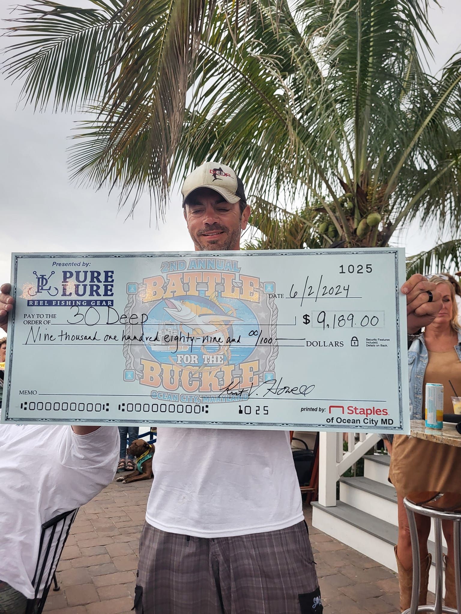 A man holding a large check that says pure lure on it