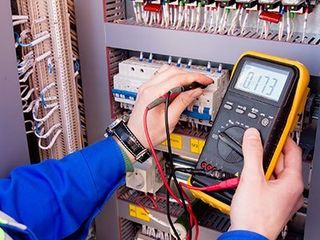Home Furnace Installation — Multimeter is in hands of engineer in Electrical Cabinet in Pittsburgh, PA
