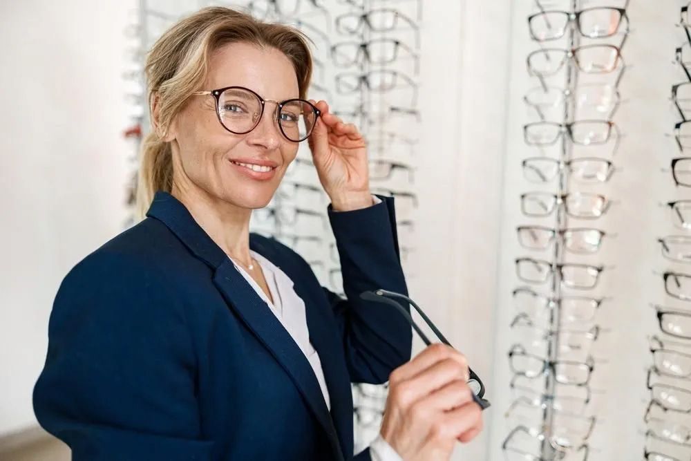 A Woman is Trying on Glasses in an Optical Shop — Michael Chu Optometrist in Cairns North, QLD