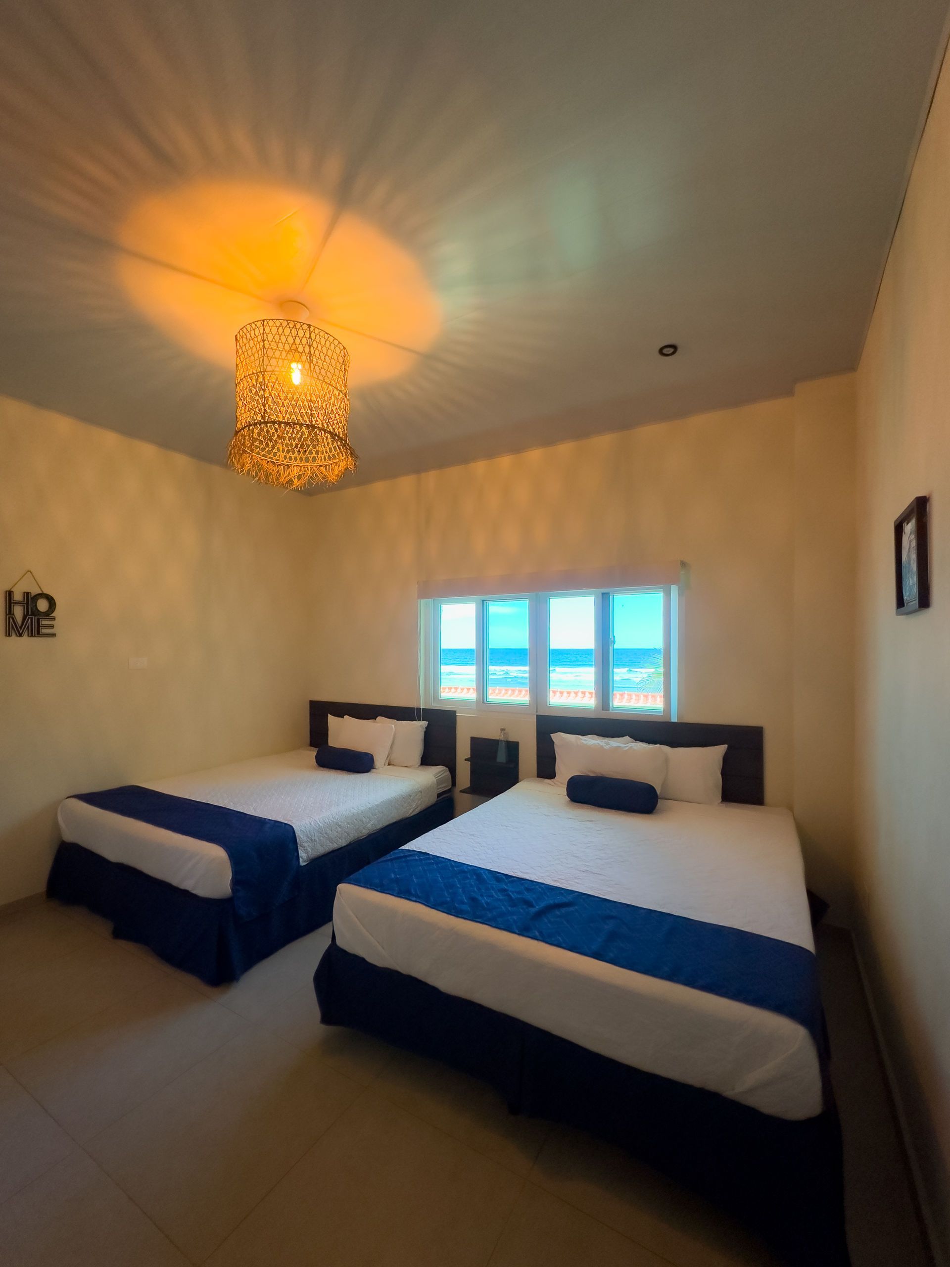 Dos camas en una habitación con vista al mar. 