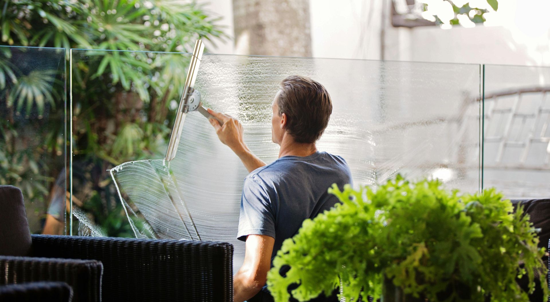 A man is cleaning a window with a squeegee.