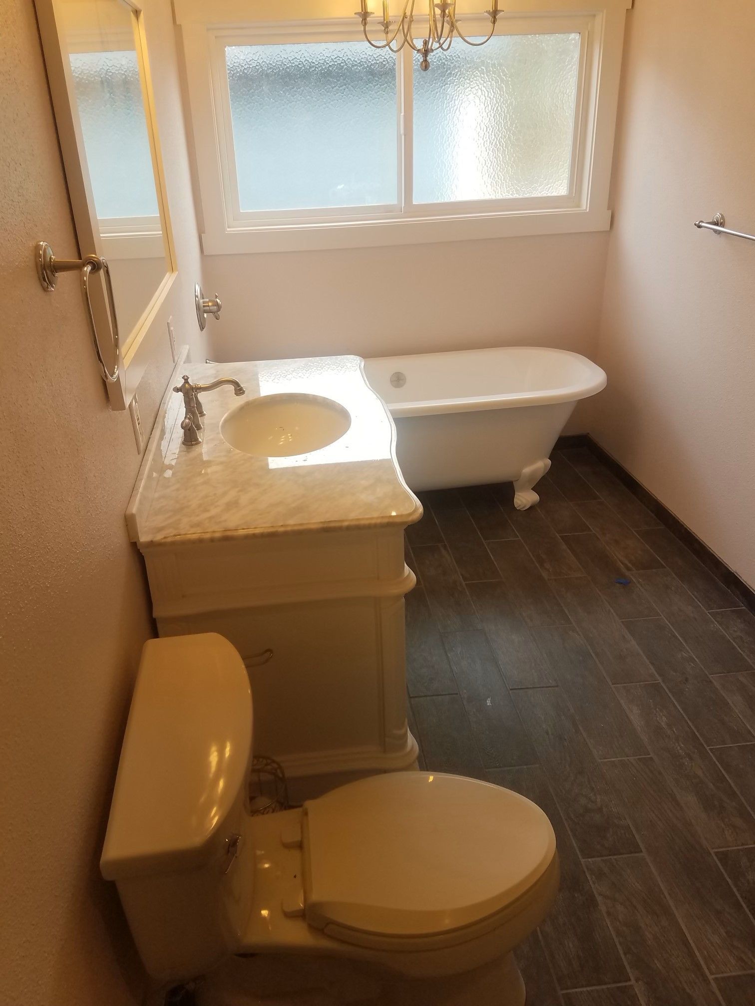 Beautiful renovated bathroom with new flooring and sink and sink countertop.