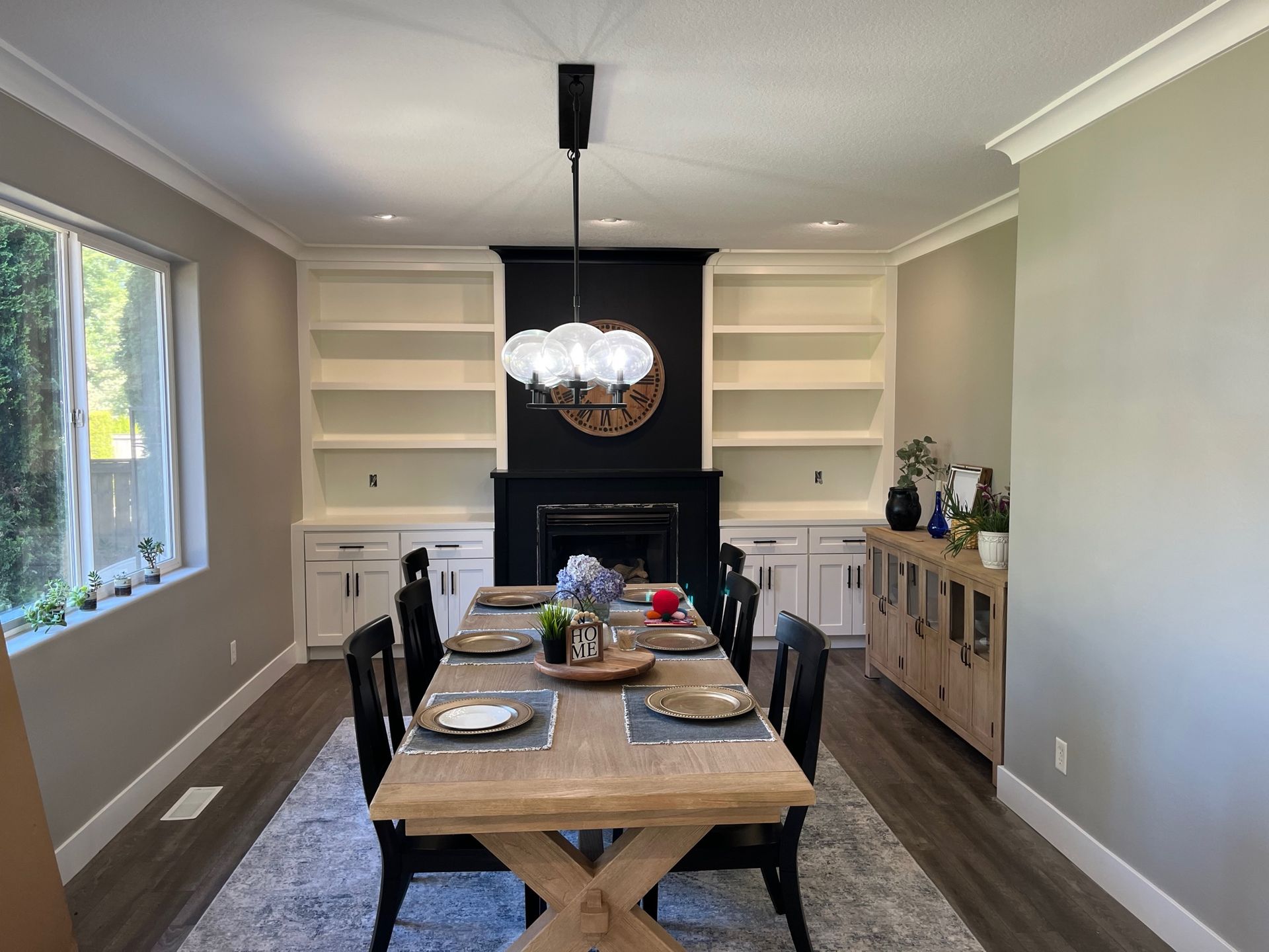 Modern and sharp looking dining table sits in the middle of dining room with freshly painted walls and shelving