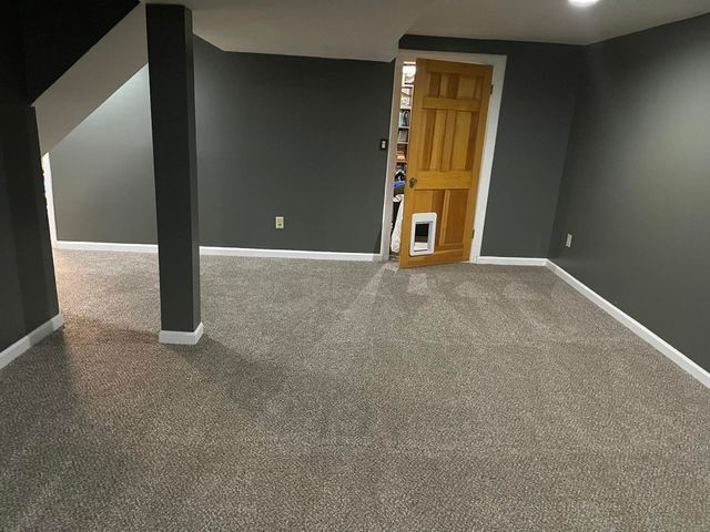 An empty room with gray walls and a yellow door.
