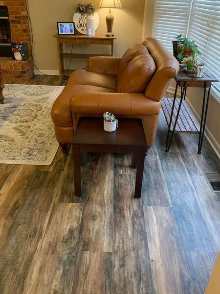A living room with a couch , chair , table and window.