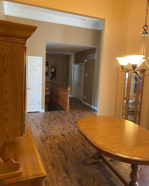 A dining room with hardwood floors and a wooden table