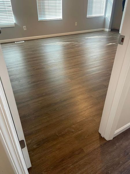 A room with a wooden floor and a white door.