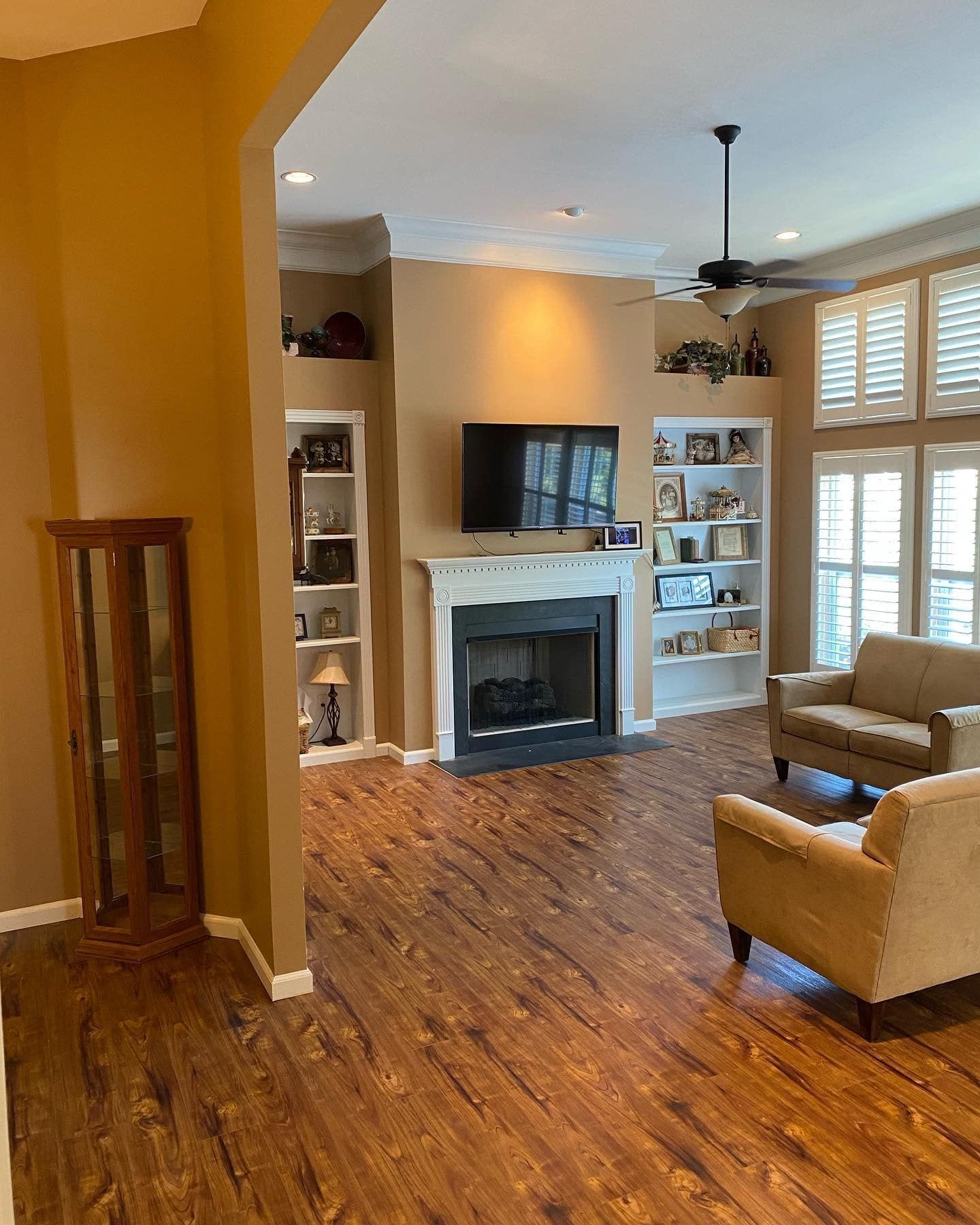 A living room with a fireplace , couch , chair and television.