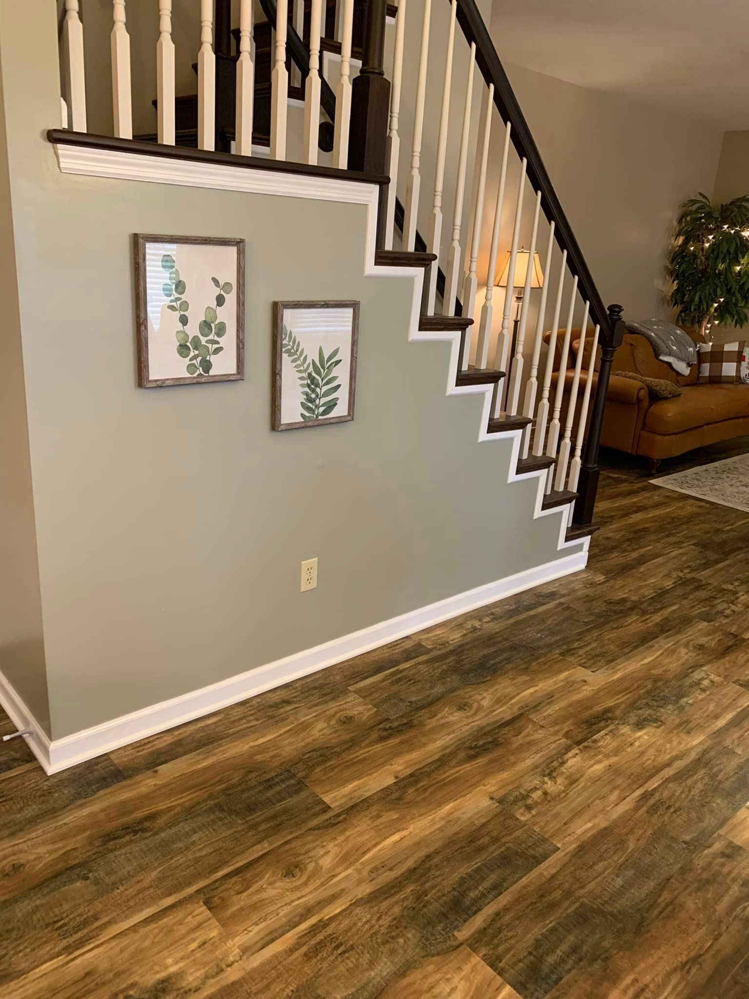 A living room with hardwood floors and stairs leading up to the second floor.