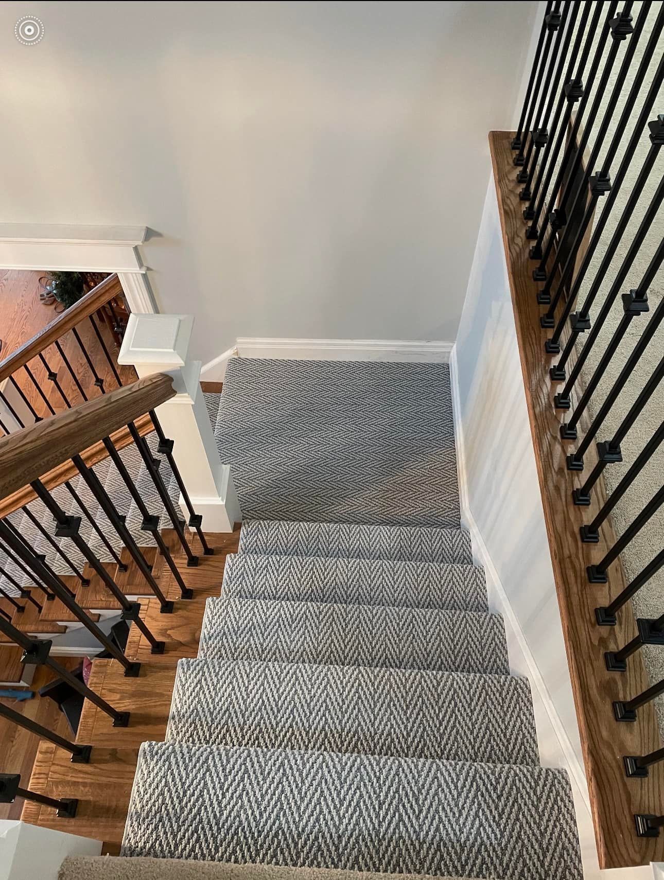 An aerial view of a staircase with a carpet on the steps.