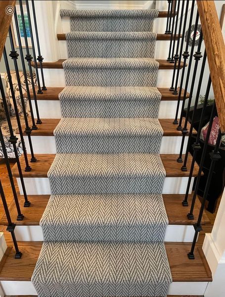 A staircase with a carpet on the steps and a wooden railing.