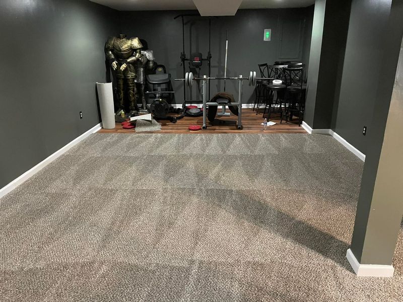 A basement with a carpeted floor and a gym equipment.