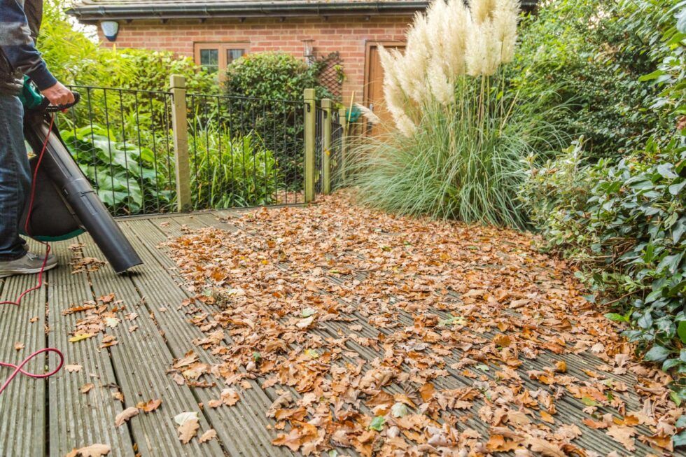 Decking being cleaned, removing leaves with air blower