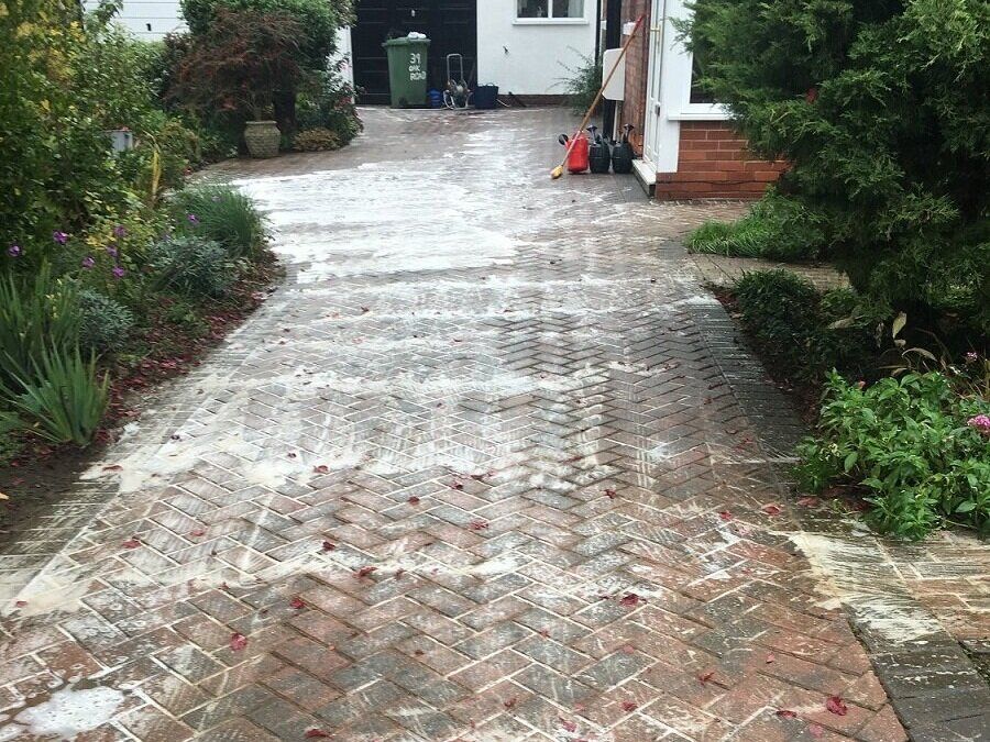 Dirty driveway cleaned by soft washing service