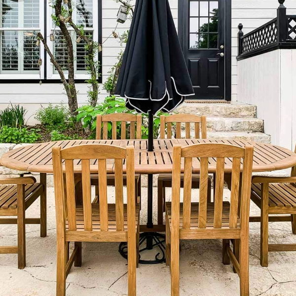Garden furniture restoration service from Hedon Exterior Cleaning. Teak patio set in garden with a black parasol.