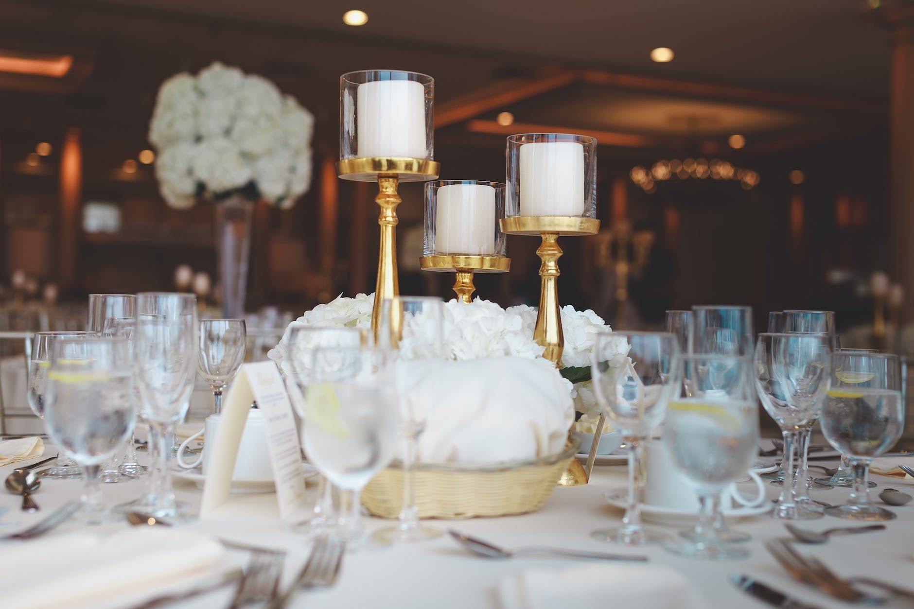 a table set for a wedding reception with candles and flowers on it .