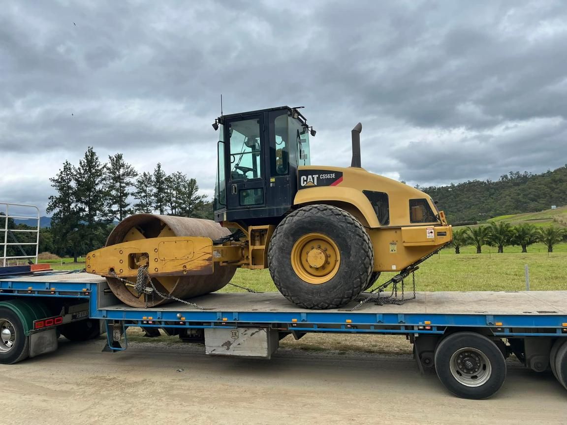 A Cat Roller Is Sitting on Top of A Flatbed Truck — White's Truck & Machinery Hire in Bouldercombe, QLD