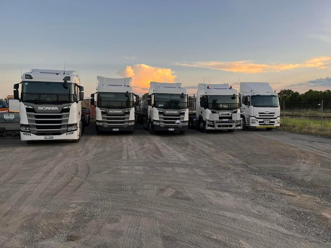 A Row of Trucks Are Parked in A Gravel Lot — White's Truck & Machinery Hire in Bouldercombe, QLD