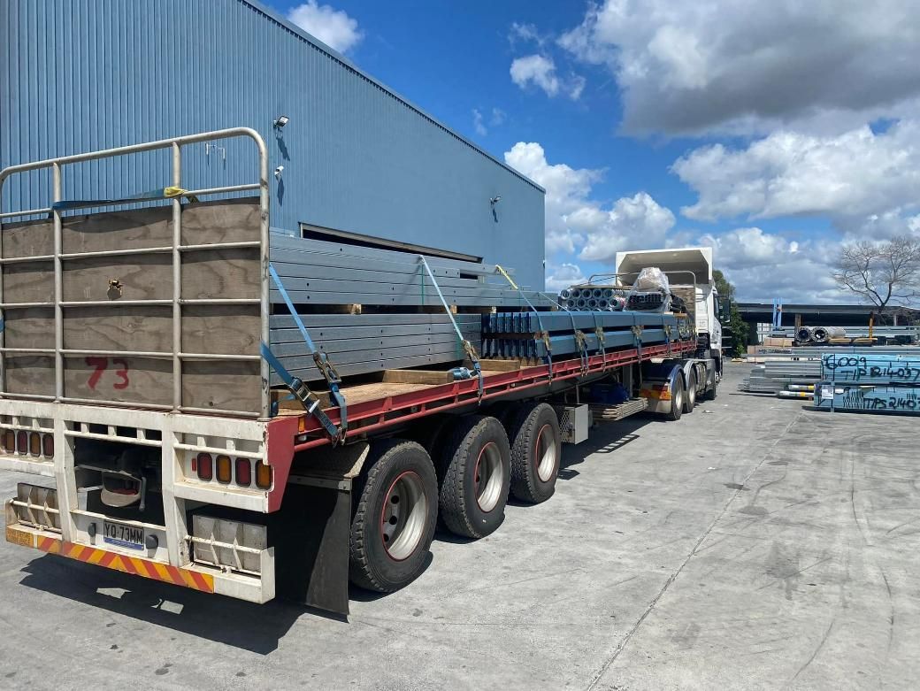 A Semi Truck Is Carrying a Large Amount of Cargo in A Parking Lot — White's Truck & Machinery Hire in Bouldercombe, QLD