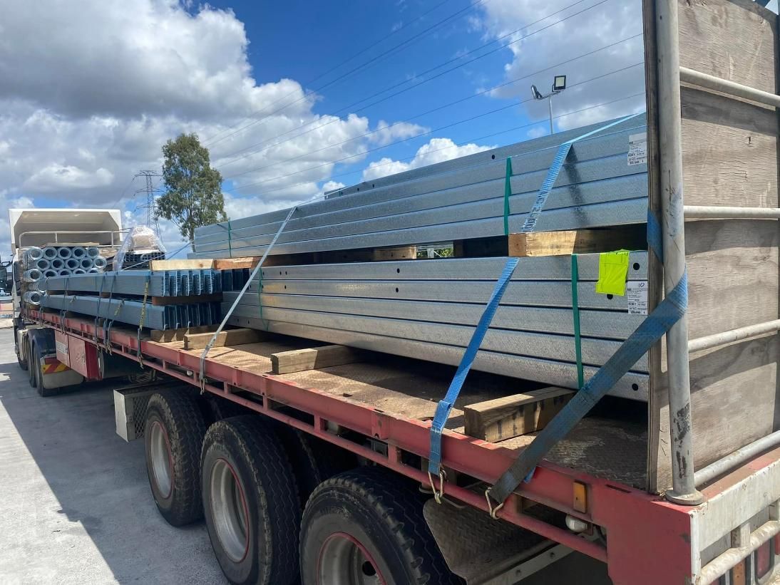 A semi truck is carrying a stack of steel beams — White's Truck & Machinery Hire in Bouldercombe, QLD