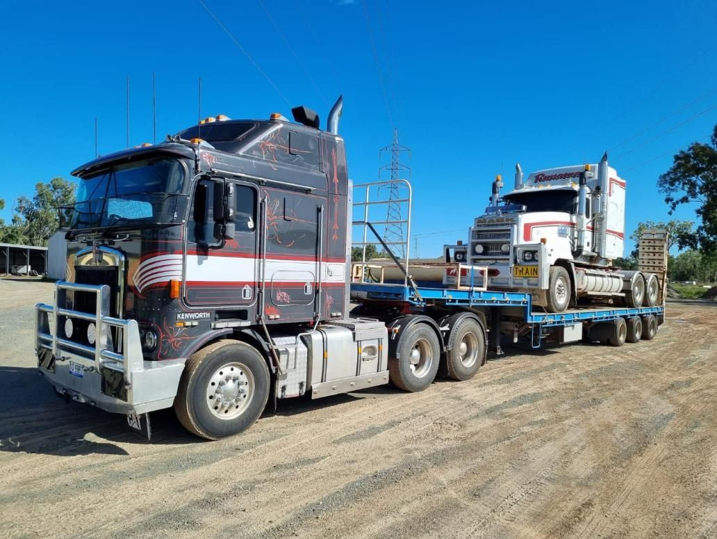 Two Semi Trucks Are Parked Next to Each Other on A Dirt Road — White's Truck & Machinery Hire in Bouldercombe, QLD