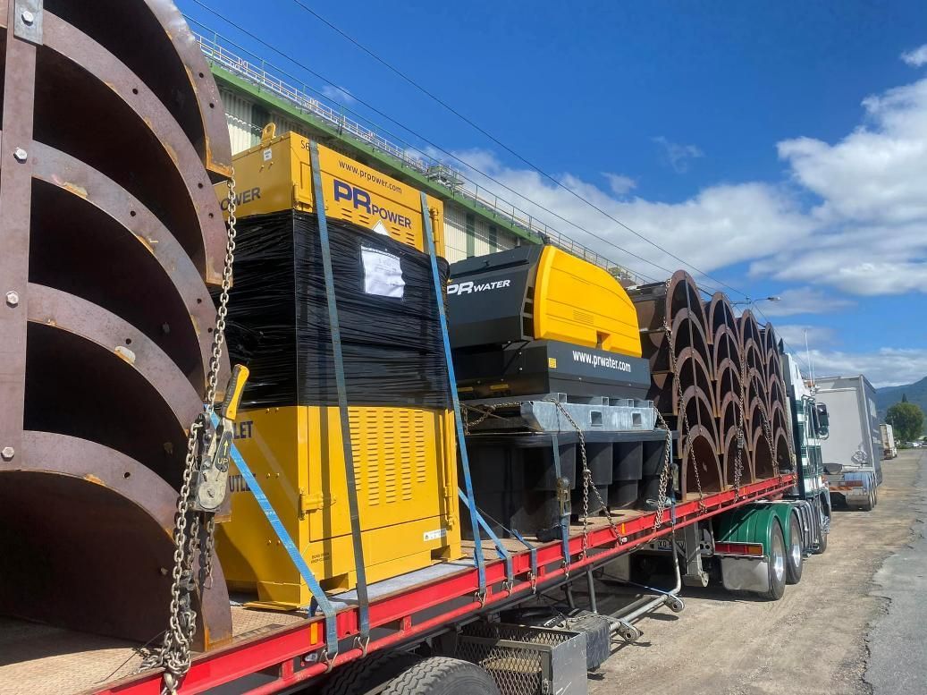 A Truck Is Carrying a Large Yellow Machine on A Red Trailer — White's Truck & Machinery Hire in Bouldercombe, QLD