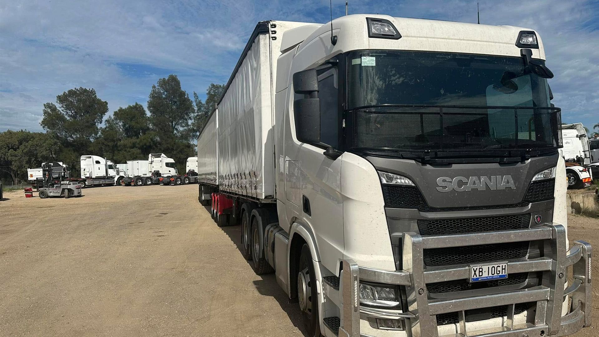 A white semi truck is parked in a dirt lot — White's Truck & Machinery Hire in Bouldercombe, QLD