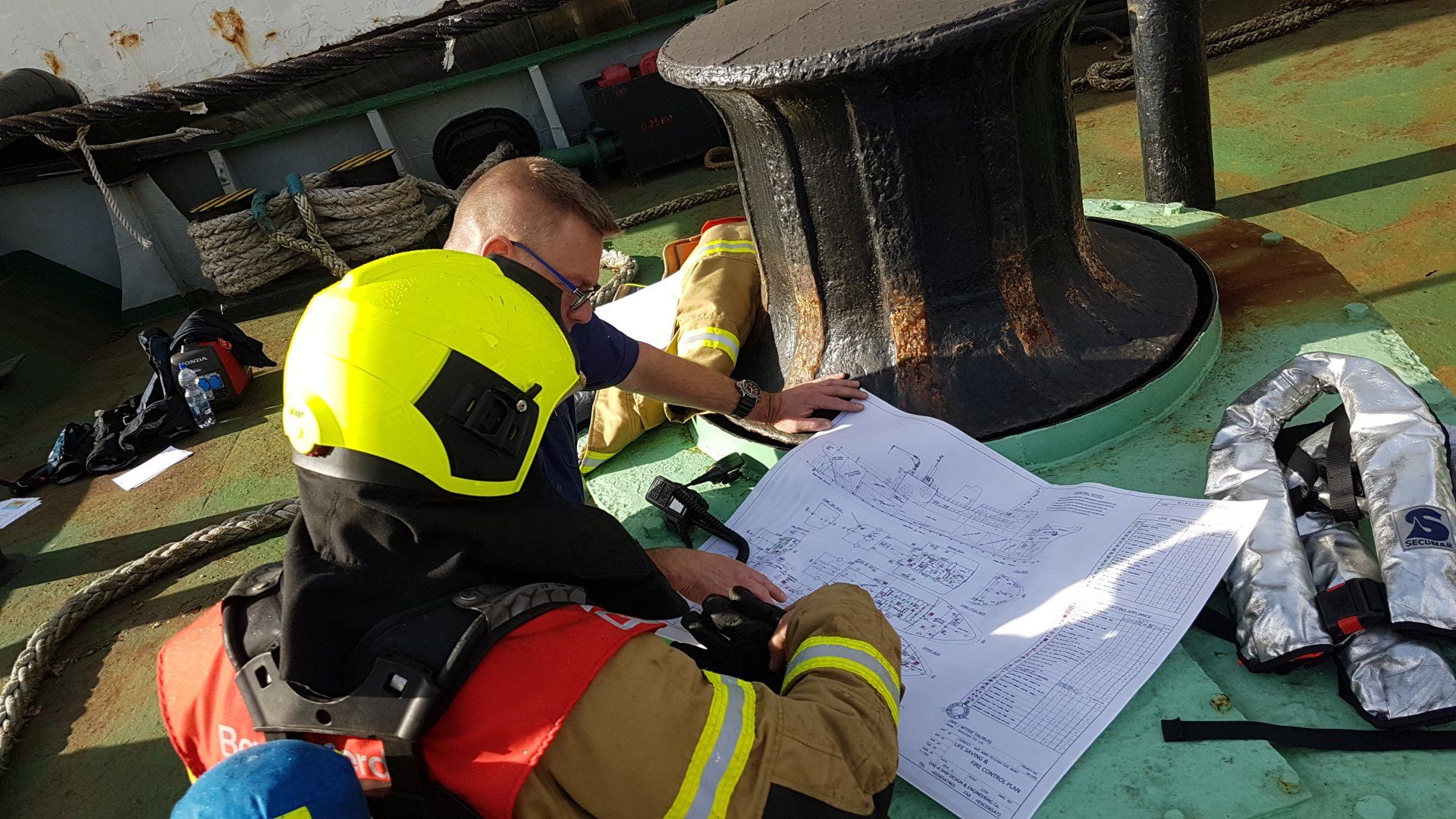 Incident commander together with a fire captain readin a ships fireplan