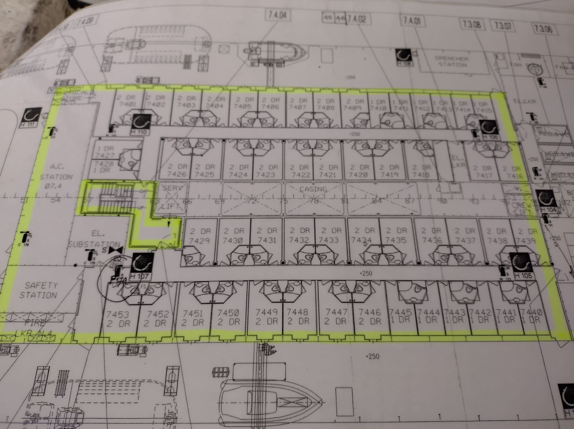 Plattegrond van een gebouw, omlijnd in geel, met kamers en gangen, gemarkeerd met tekst en symbolen.
