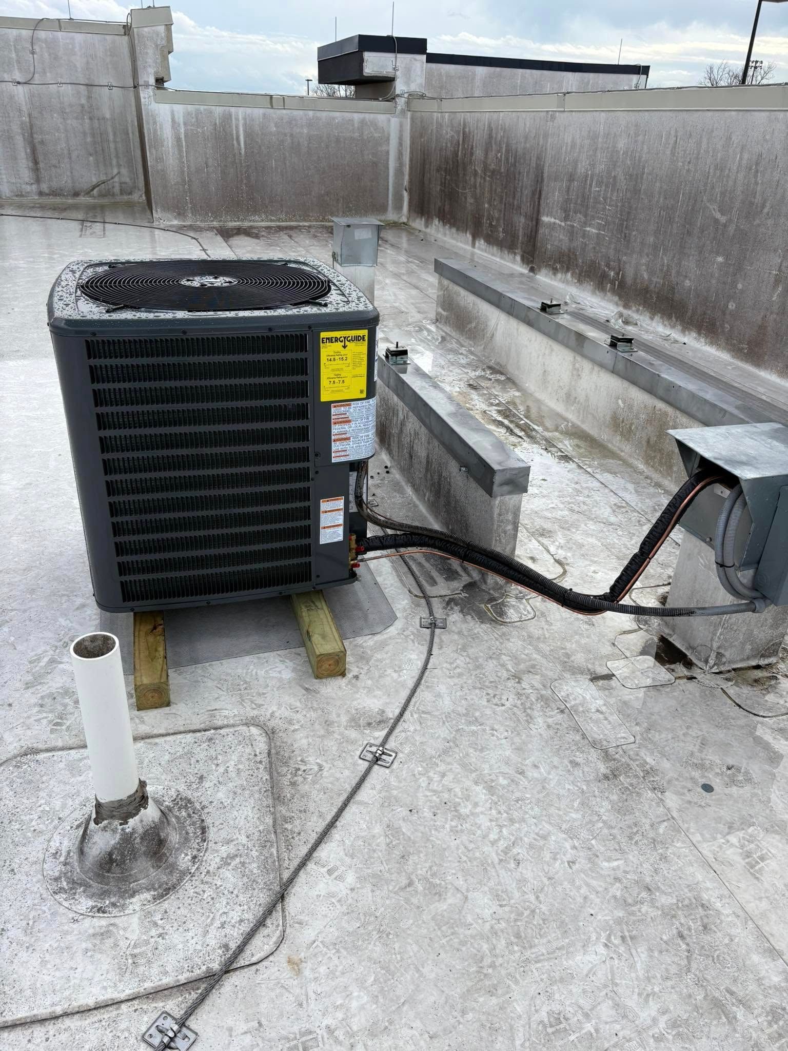 An air conditioner is sitting on top of a concrete roof.