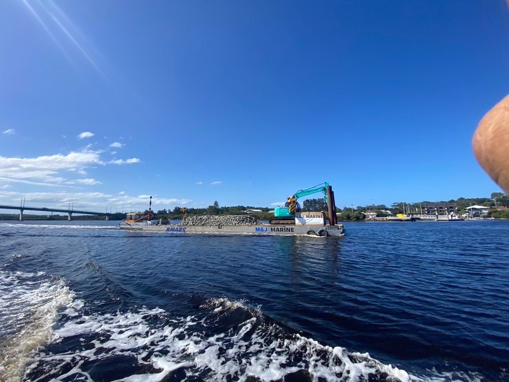 Excavator and Pile of Rocks — M&J Marine Services in Medowie, NSW