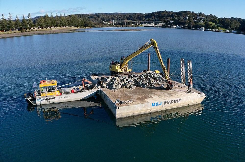 Yellow Excavator Scattered the Rocks — M&J Marine Services in Medowie, NSW