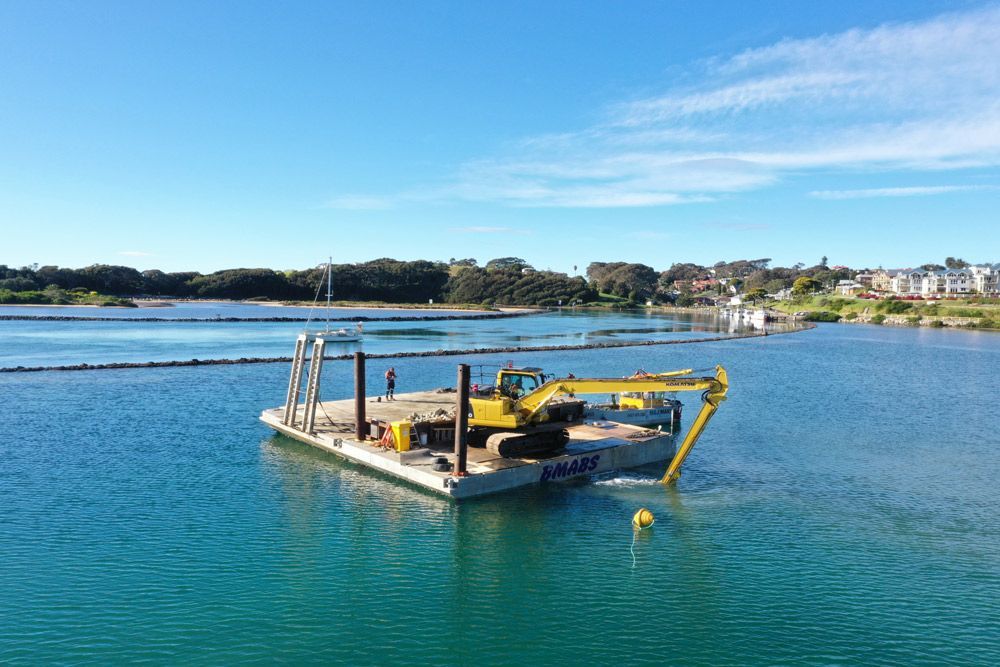 Yellow Excavator Along the Coast — M&J Marine Services in Medowie, NSW