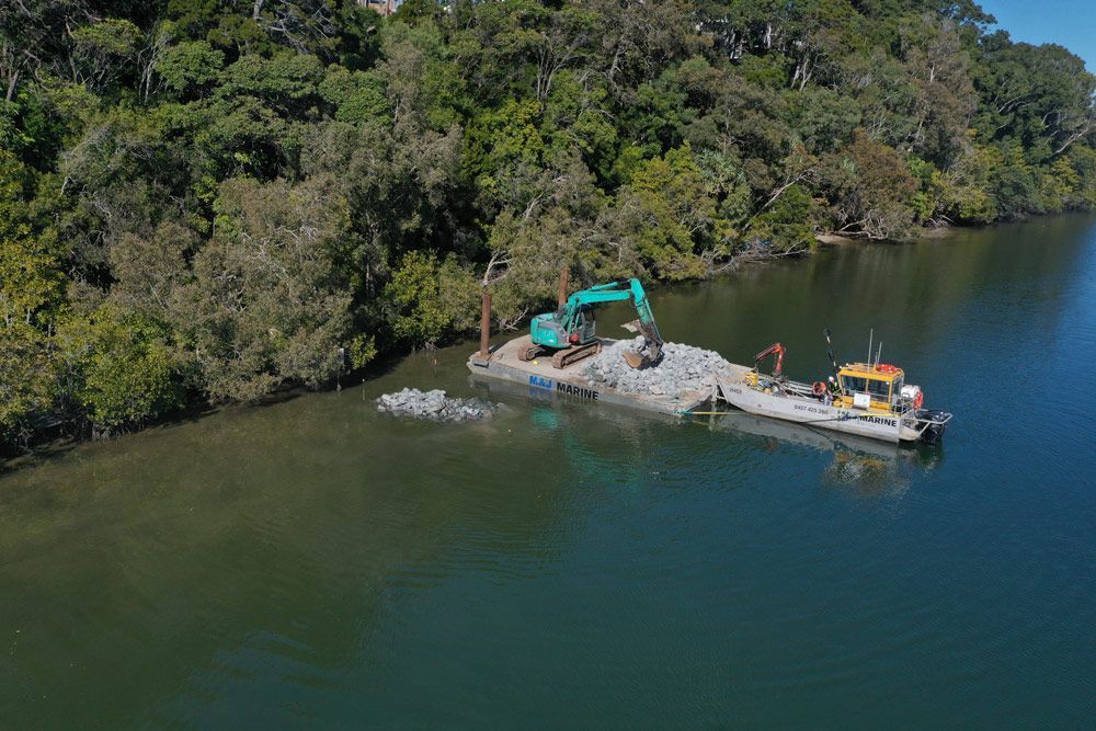 Excavator And Boat Along the Coast — M&J Marine Services in Medowie, NSW