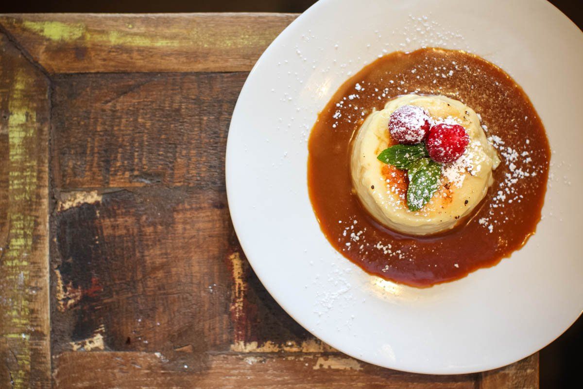 A white plate topped with a dessert on a wooden table.