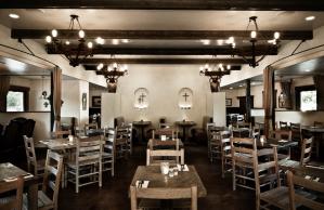 A restaurant with tables and chairs and a chandelier hanging from the ceiling.