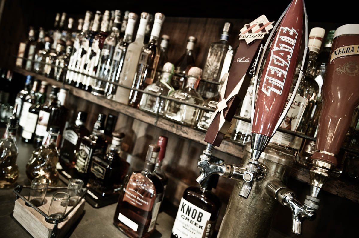 A bar filled with bottles of liquor including knob