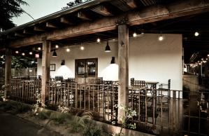 A restaurant with tables and chairs under a wooden roof.